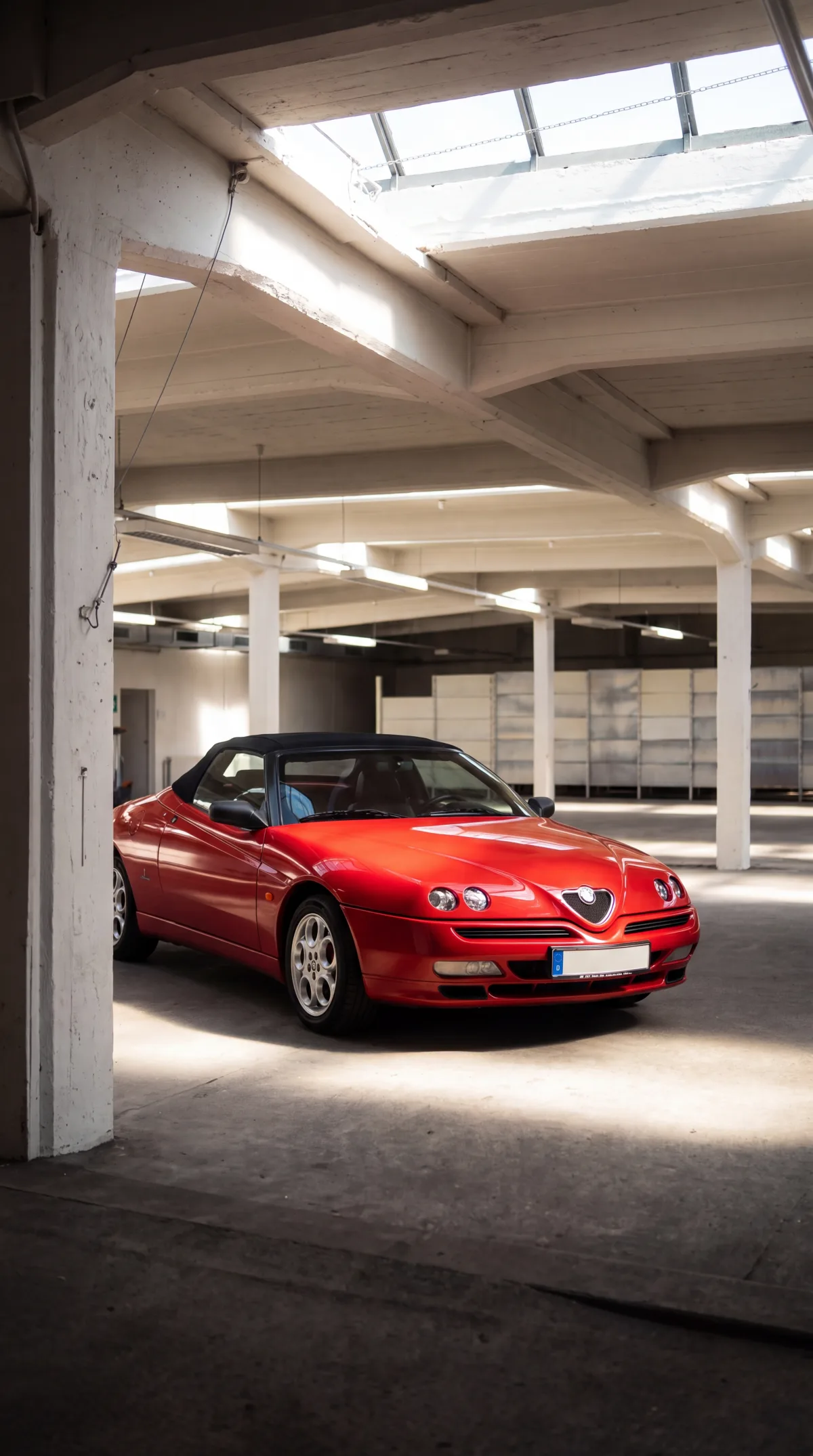 Roter Alfa Romeo Spider unter dem Oberlicht einer historischen Parketage